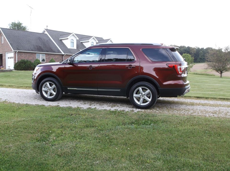Maroon Ford Explorer parked on a gravel driveway