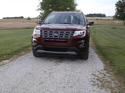 2016 Ford Explorer - A maroon 2016 Ford Explorer is parked on a gravel driveway with a field in the background.