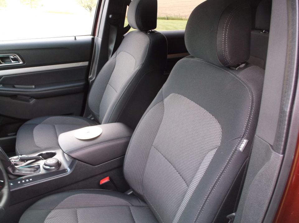 Interior view of car seats and center console with a CD on the armrest