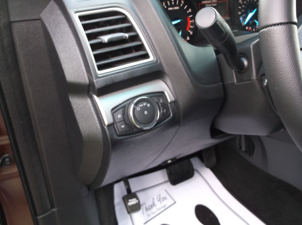 Dashboard interior with air vent, headlight controls, and steering wheel. Floor mats read "Thank You"