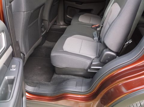 2016 Ford Explorer - Interior view of the back seats and door panel of an orange SUV.