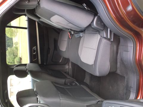 2016 Ford Explorer - The interior of the vehicle shows the rear seating area with fabric upholstery and dark trim.