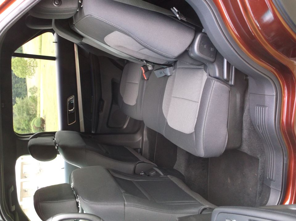 Back seats and door panel of an SUV. The seats are dark gray with lighter gray fabric inserts