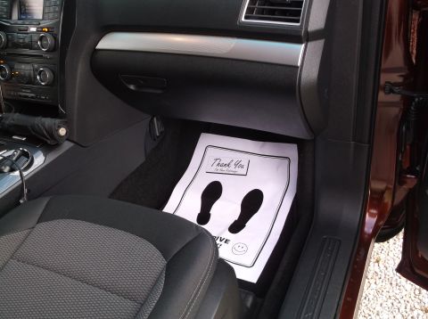 2016 Ford Explorer - The interior of a car shows a floor mat with footprints and text, along with the dashboard and a seat.