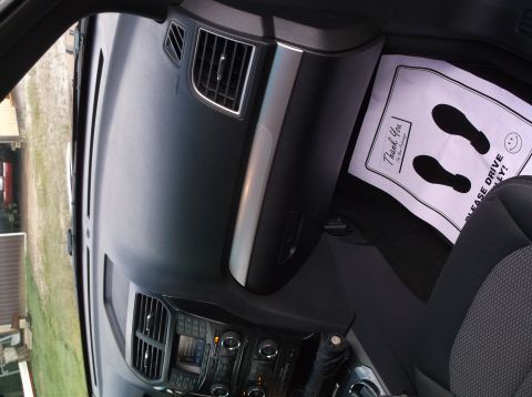 2016 Ford Explorer - Interior view of a vehicle's dashboard, showing air vents, controls, and a floor mat with 'Thank You' and 'Please Drive Safely' text.