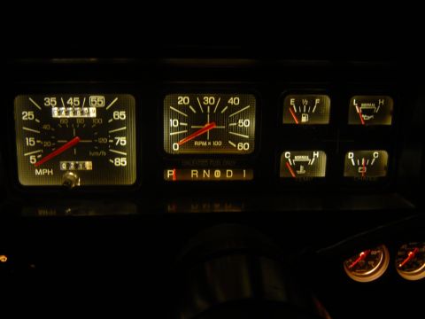1986 Ford Bronco - Dashboard gauges for a 1986 Ford Bronco, illuminated at night.