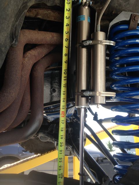 1979 Ford Bronco - Measuring suspension travel with a tape measure next to exhaust and coil spring.