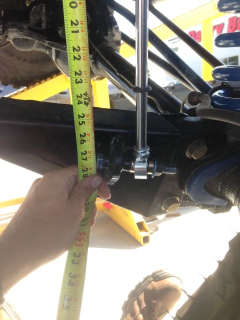 1979 Ford Bronco - A tape measure is used to check the height of the vehicle's suspension components.