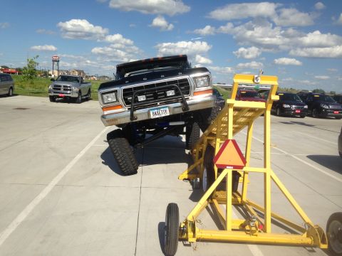 1979 Ford Bronco - A lifted 1979 Ford Bronco is positioned on a yellow ramp, with other vehicles visible in the background.