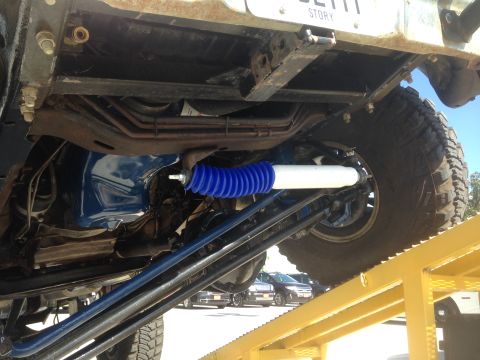 1979 Ford Bronco - The underside of a vehicle is shown, focusing on the suspension system with a blue shock absorber.