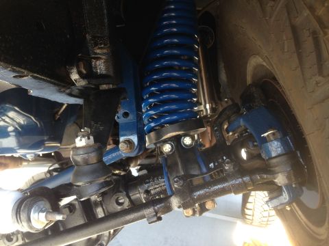 1979 Ford Bronco - Vehicle suspension components, including a blue coil spring and various linkages.