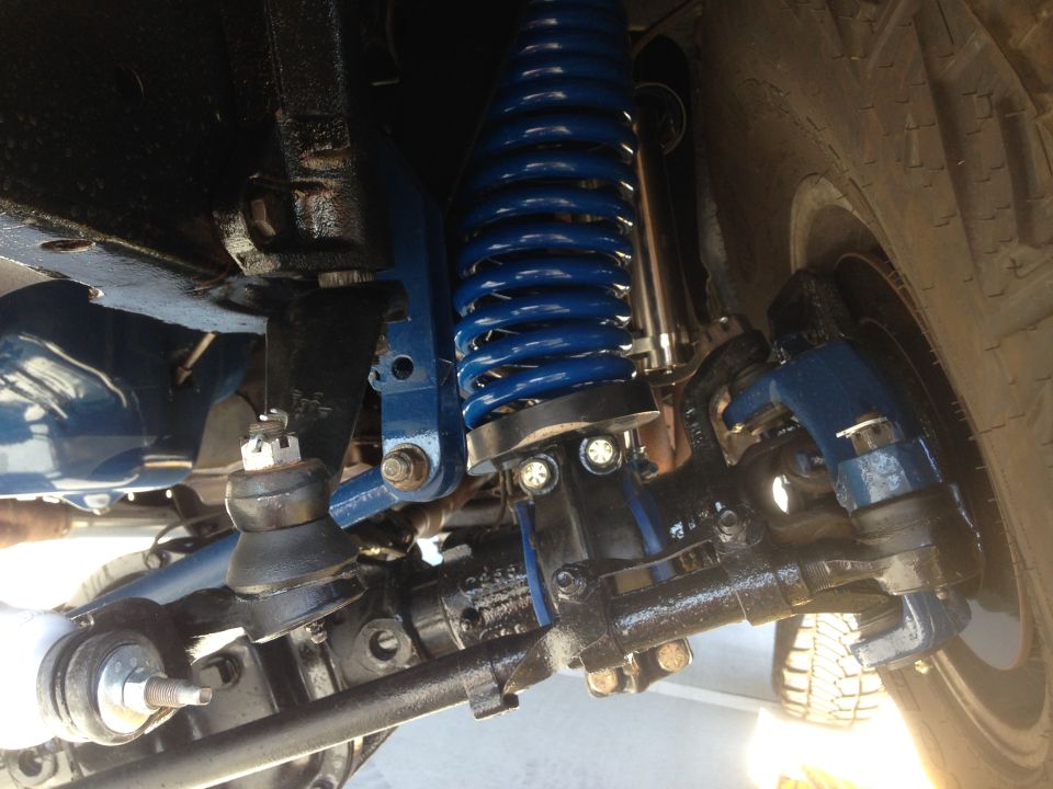 Close-up of blue coil spring and black suspension parts on a vehicle