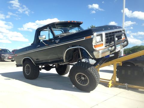 1979 Ford Bronco - This lifted 1979 Ford Bronco features a custom suspension setup and a heavy-duty front bumper, displayed on a yellow ramp.