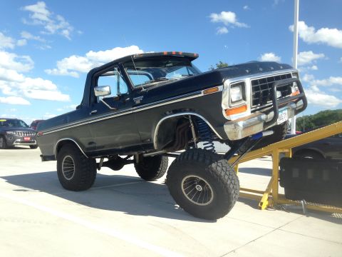 1979 Ford Bronco - Modified 1978 Ford Bronco with custom suspension and brush guard is shown on a ramp.