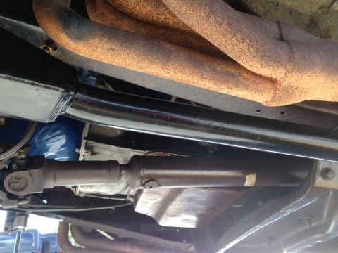 1979 Ford Bronco - Close-up view of the undercarriage, showing exhaust headers and a driveshaft.