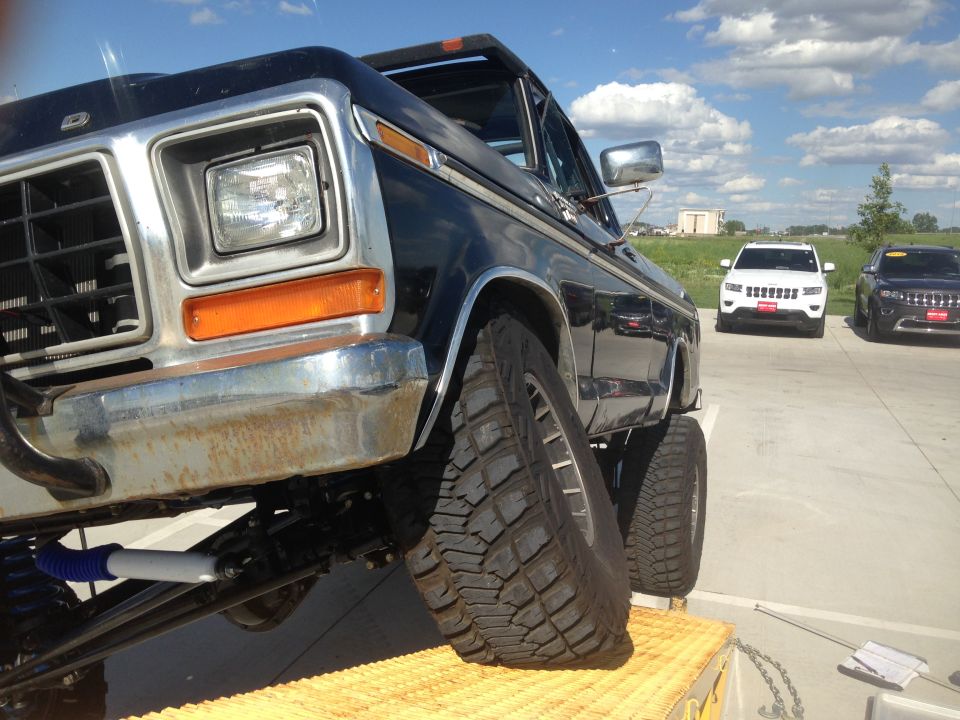 Black 1979 Ford Bronco with lifted suspension and large tires, viewed from a low front angle