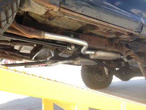 1979 Ford Bronco - The underside of a 1979 Ford Bronco reveals its suspension and exhaust system, with visible rust on the frame.