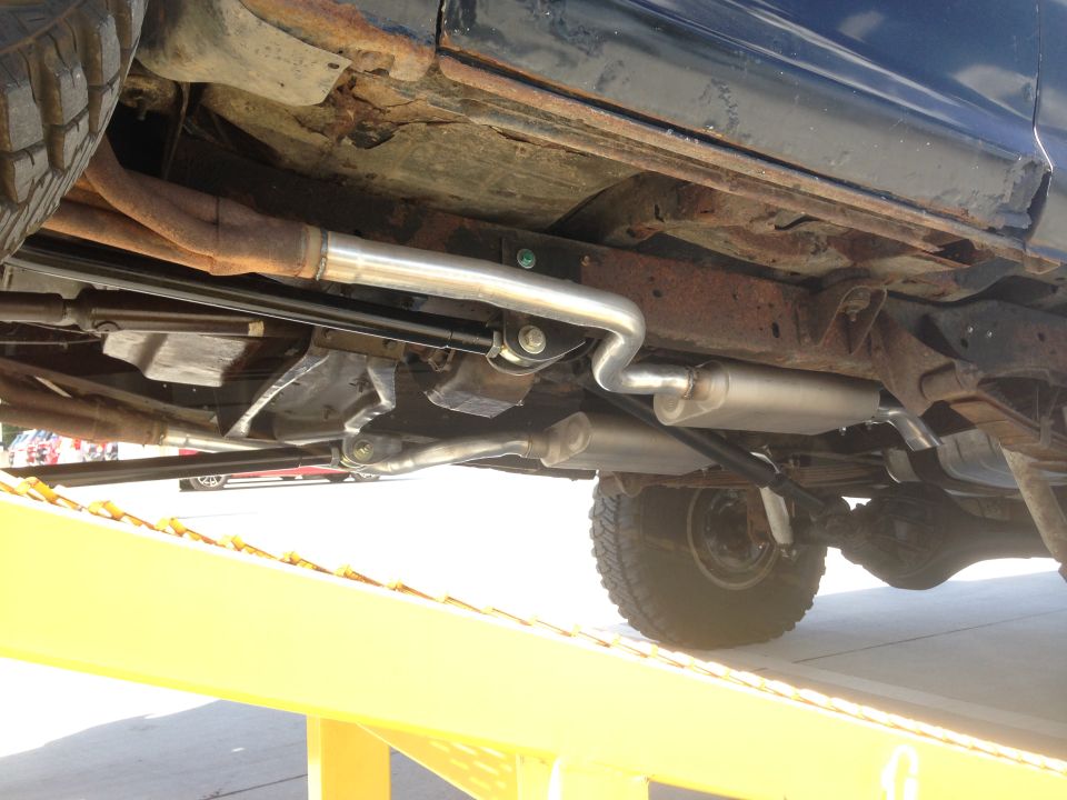 Undercarriage of a 1979 Ford Bronco showing rusty frame, exhaust system, and suspension components
