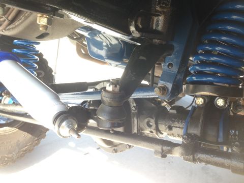 1979 Ford Bronco - This image shows the undercarriage of a vehicle, focusing on the steering and suspension system with bright blue springs.