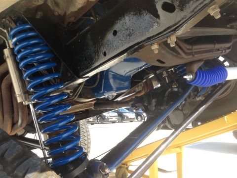 1979 Ford Bronco - Close-up view of the modified suspension system, showing blue springs and shocks.