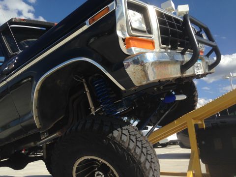 1979 Ford Bronco - This 1979 Ford Bronco features a lifted suspension with bright blue springs and aggressive off-road tires.