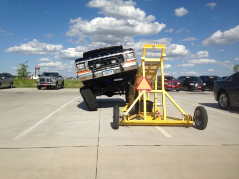 1979 Ford Bronco - A modified Ford F-Series truck is positioned on a yellow ramp in a parking lot.