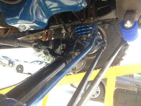 1979 Ford Bronco - The photo shows the undercarriage of a vehicle, focusing on its suspension components and drivetrain.