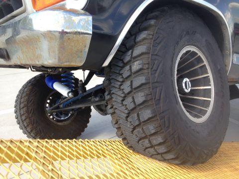 1979 Ford Bronco - Close-up of the front suspension and large tires on a 1979 Ford Bronco.