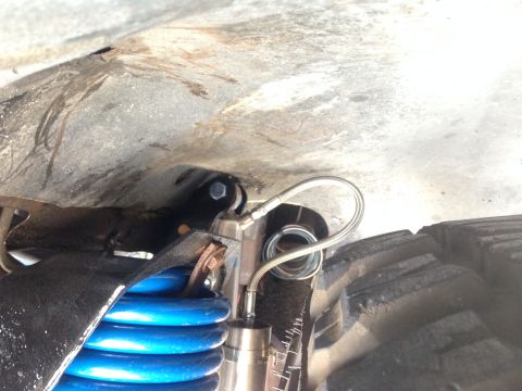 1979 Ford Bronco - A detailed view of the suspension system, showing blue coil springs and a shock absorber.