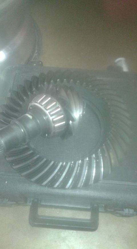 1996 Ford Bronco - Close-up of a differential gear set, showing the pinion and ring gear. Text at the bottom reads SUPERMOTORS.NET.