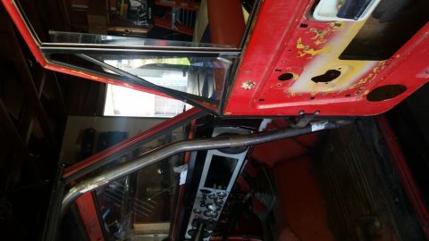 1968 Ford Bronco - The interior of a vehicle is shown, focusing on the door frame and dashboard area with a roll cage installed.