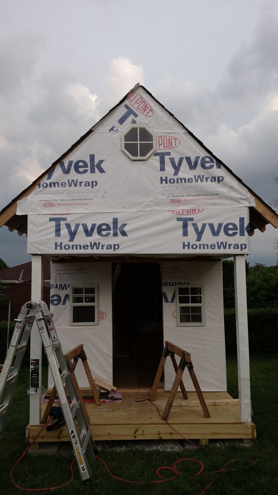Playhouse under construction with Tyvek wrap and a ladder