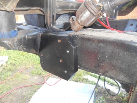 1972 Ford Bronco - Close-up view of a custom bracket attached to a vehicle's frame, showing mechanical components and wiring.