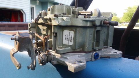 1978 Chevrolet C/K Pickup - A remachined carburetor, identified by a UREMCO 3-3798 label, is shown resting on a blue surface.