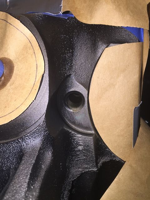 1978 Ford Bronco - This is a close-up view of a black engine component, partially covered with masking tape.