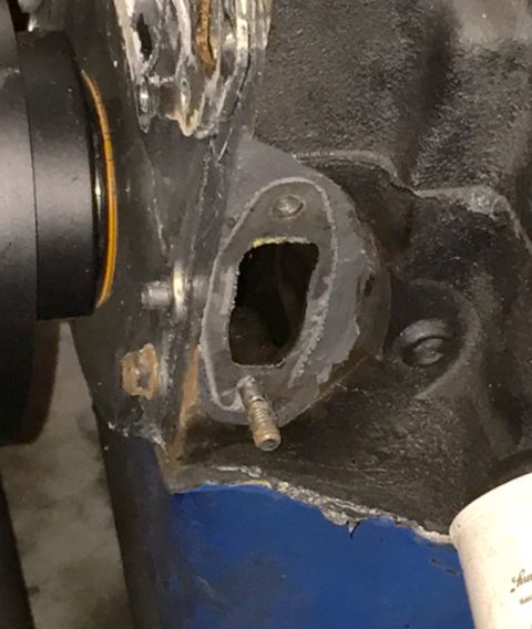 1978 Ford Bronco - Close-up of an engine block's surface, revealing a detached gasket and a threaded bolt.