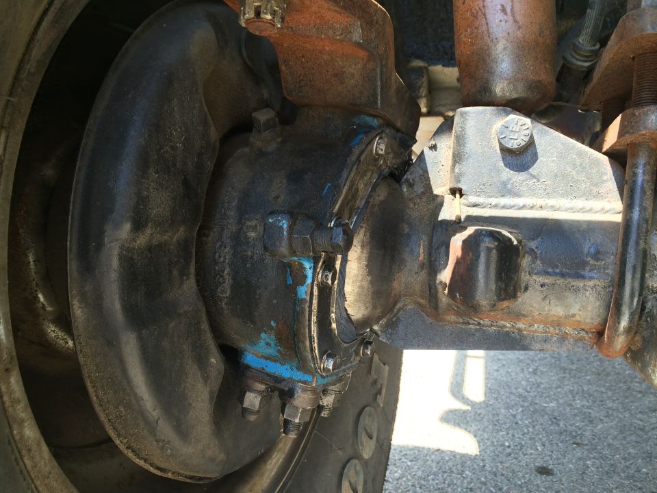 Close-up of a truck's rear axle housing, brake drum, and suspension components