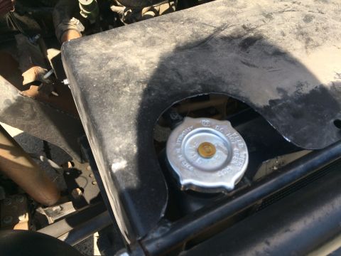 1987 Suzuki Samurai - Close-up of a radiator cap in an engine bay, with a warning to not open when hot.