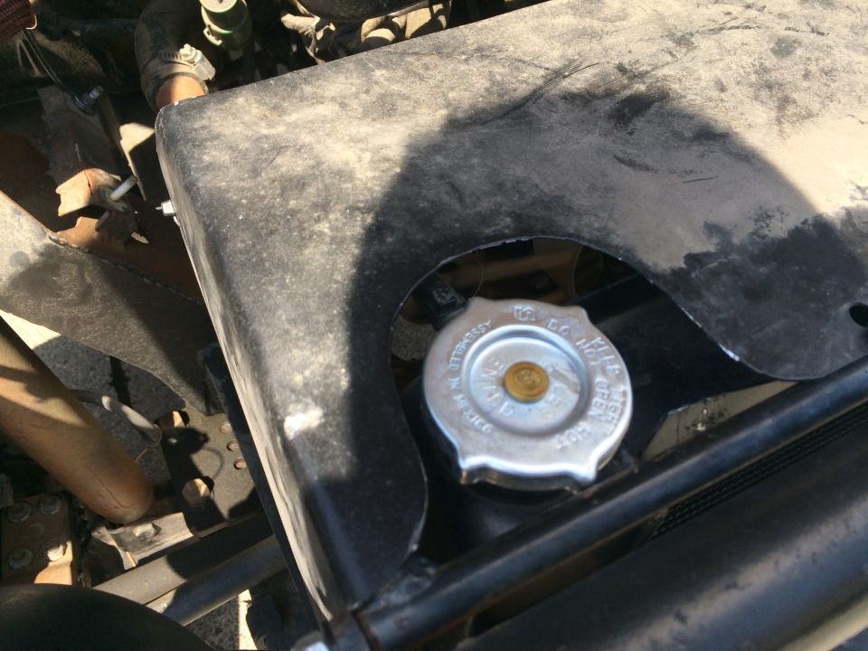 Radiator cap with text 'Do Not Open Hot' in an engine bay