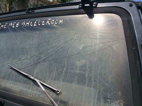 1987 Suzuki Samurai - Windshield is heavily cracked, with the sun glinting off the glass.