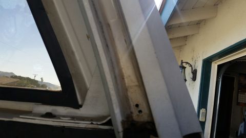 1992 Ford Bronco - This photo shows a close-up view of the window frame and seal of a vehicle, with a landscape visible through the window.