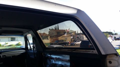1992 Ford Bronco - Looking out from the interior of a vehicle at a suburban street scene with other vehicles and houses.