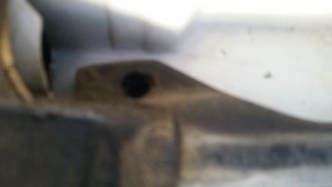 1992 Ford Bronco - A close-up view of a vehicle's body panel, showing a hole and some dirt, with a watermark at the bottom.