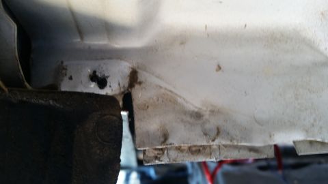 1992 Ford Bronco - Detail of a white vehicle's body panel, revealing areas of rust and accumulated dirt.
