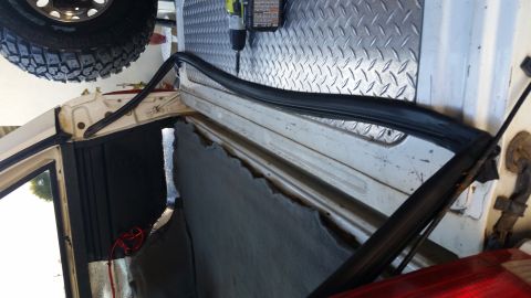1992 Ford Bronco - The rear door frame of a 1992 Ford Bronco is visible with new weatherstripping being installed.