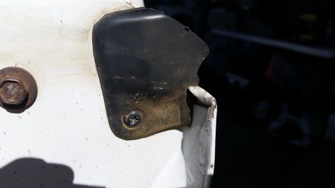 1992 Ford Bronco - A close-up view of a vehicle's door hinge bracket, showing wear and tear.