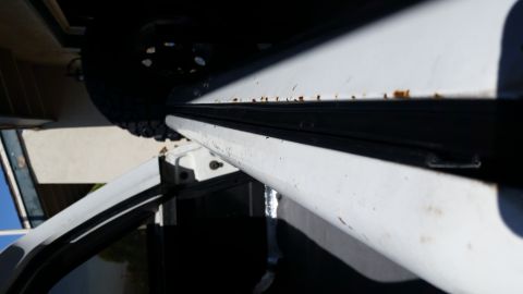1992 Ford Bronco - Close-up of a white vehicle's door frame, showing rust and weatherstripping.