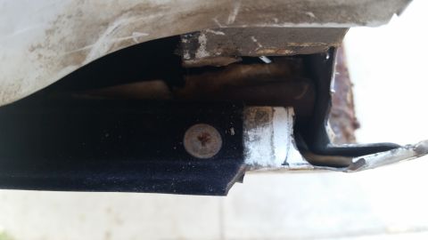 1992 Ford Bronco - Detail of vehicle body trim and weatherstripping, showing a screw fastener.