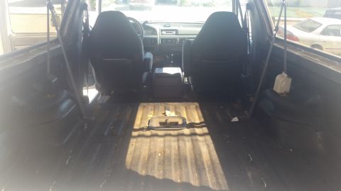 1992 Ford Bronco - The interior of a 1992 Ford Bronco reveals worn seats and a utilitarian truck bed, consistent with its model year.