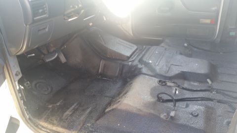 1992 Ford Bronco - The interior floor of a vehicle shows exposed wiring and a central hump, with a watermark for Supermotors.net.